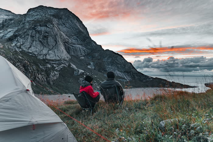 Two camp chairs at sunset overlooking a Lofoten fjord