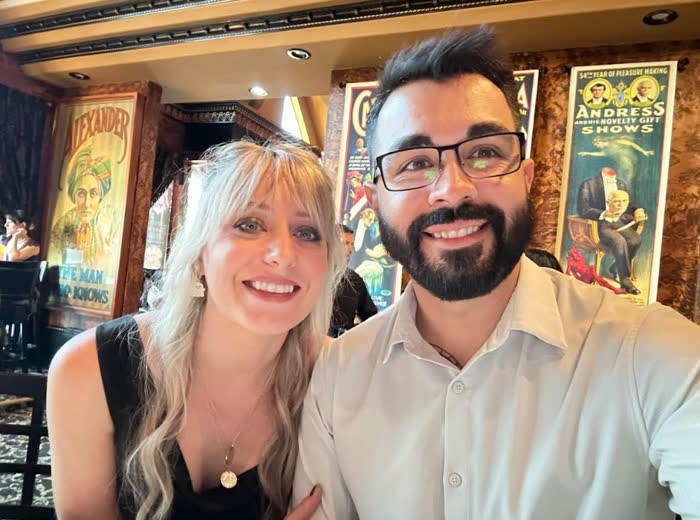 Big smiles at the Magic Castle, vintage magician posters behind us